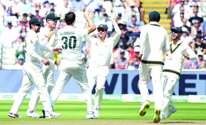 Australia's Pat Cummins (center) celebrates with teammates after dismissing England's Jos Buttler during day five of the first Ashes Test cricket match between England and Australia at Edgbaston in Birmingham, England on Monday.