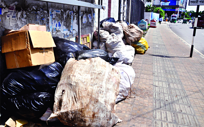 Rubbish and garbage bags piled up by city corporation's cleaners on footpath nearby the Police Plaza at Gulshan-1 in Dhaka causing irritation to the pedestrians.