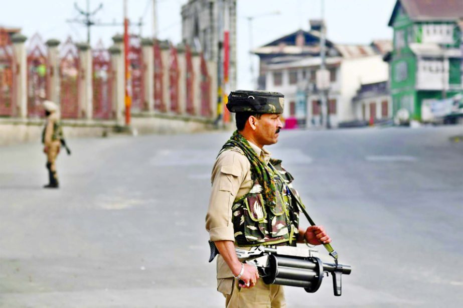 Security personnel stand guard on a street during a curfew in downtown Srinagar.