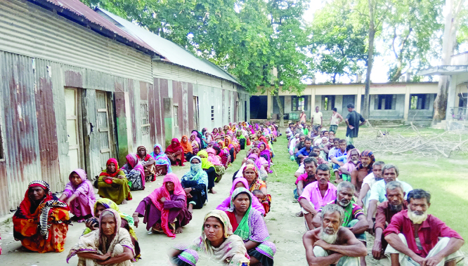 JAMALPUR: Flood- hit people at Beltoil Dakhil Madrasa in Melandah Upazila waiting in queue for relief goods on Wednesday.