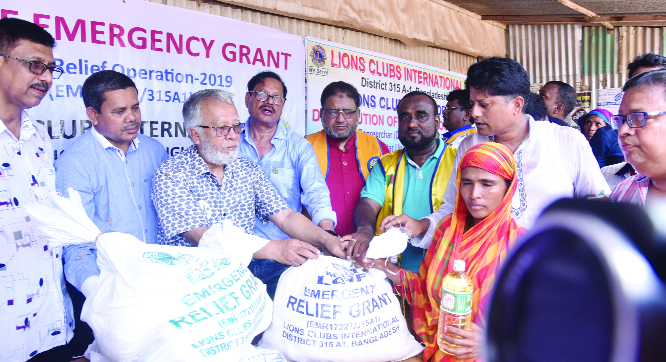 FARIDPUR : Dr Shahidul Islam MJF, District Governor, District 315A1 along with other officials of Lions Club International distributing relief materials among the flood -hit people at Haziganj Bazar on Monday.