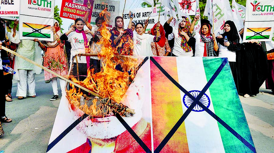 Activists of the 'Youth Forum for Kashmir' group shout slogans as they burn a picture of Indian Prime Minister Narendra Modi and the Indian flag during a protest in Lahore. Internet photo