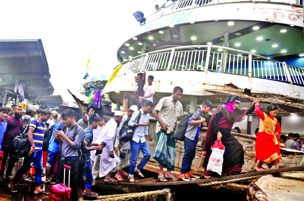 Thousands of home-bound passengers leave Dhaka through railways, highways and waterways to celebrate Eid-ul-Azha on Thursday. Photo shows Eid home goers boarding a launch at the Sadarghat Terminal in city despite heavy rain.
