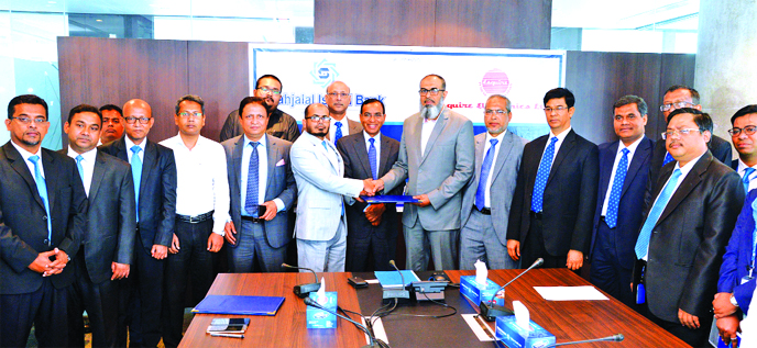 Md. Marufur Rahman Khan, Head of Card Division of Shahjalal Islami Bank Limited and Md. Manzurul Karim, GM (Sales & Marketing) of Esquire Electronics Limited, exchanging documents after signing an agreement in presence of M Shahidul Islam, Managing Direct