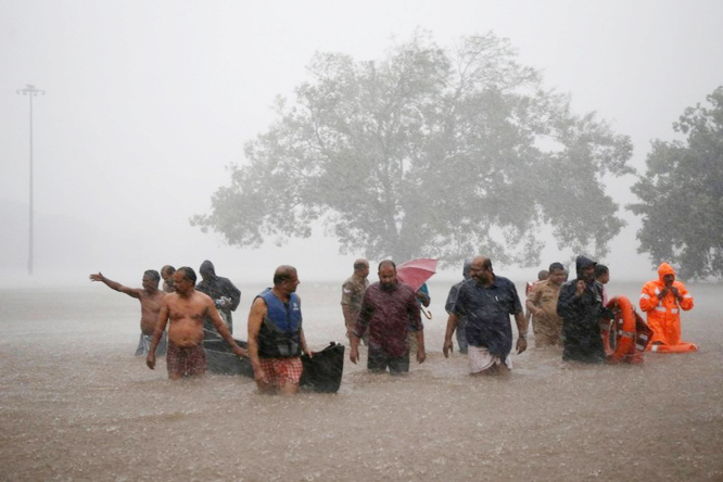 Members of a rescue team wade through a water-logged area during heavy rains on the outskirts of Kochi in the southern state of Kerala, India on Thursday.