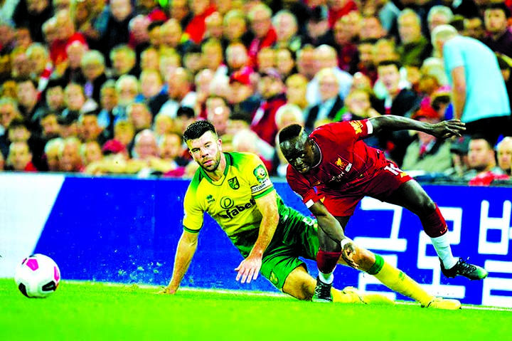 Norwich City defender Grant Hanley (left) vies with Liverpool striker Sadio Mane during the Premier League game at Anfield on Friday night.