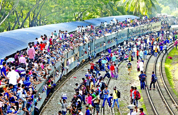 Thousands of Eid holydaymakers managed their places on roof-top of compartments of train despite the authorities embargo. This photo was taken from Biman Bandar station area on Saturday.
