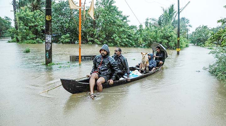Residents are being evacuated from their home to a safer place following floods warnings, on a wooden boat in Kochi in the Indian state of Kerala.