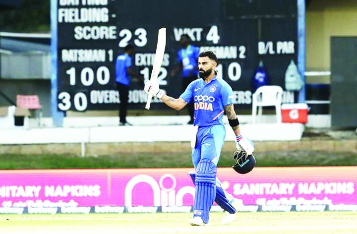 Indian captain Virat Kohli raises his bats to celebrate reaching a century during the third One-Day International cricket match against West Indies in Port of Spain, Trinidad on Wednesday.