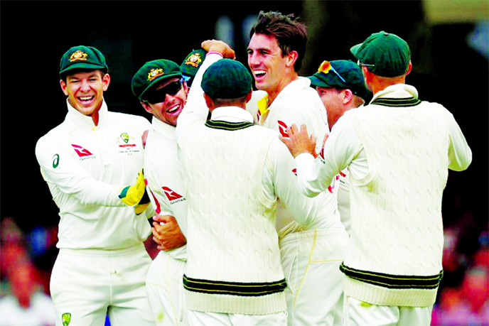 Australia's Pat Cummins (centre) celebrates with teammates after they took the wicket of England's Rory Burns for 53 runs at the second Ashes Test at Lord's on Thursday.