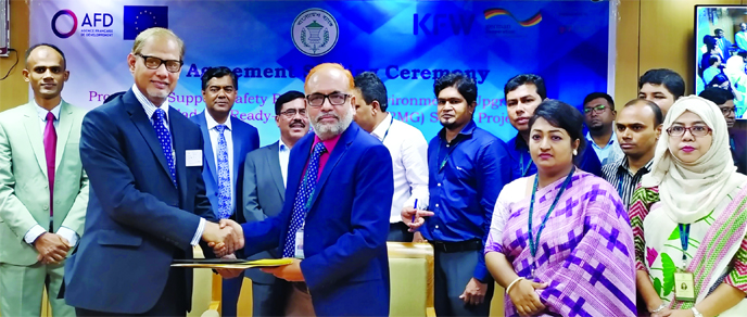 Md Abdul Mannan, General Manager of Bangladesh Bank (BB) and Md Sazzad Hossain, Deputy Managing Director of Bank Asia Ltd, exchanging an agreement signing document at the BB's head office in the city recently. BB's Deputy Governor SM Moniruzzaman and Ba