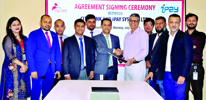 Md Mustafizur Rahman Ujjal, Head of ADC of City Bank and Zakaria Swapan, CEO of iPay Systems Ltd, exchanging an agreement signing document at the bank's corporate office in the city recently. Masudul Haque Bhuiyan, Head of Cards of the Bank and Raihan Fa