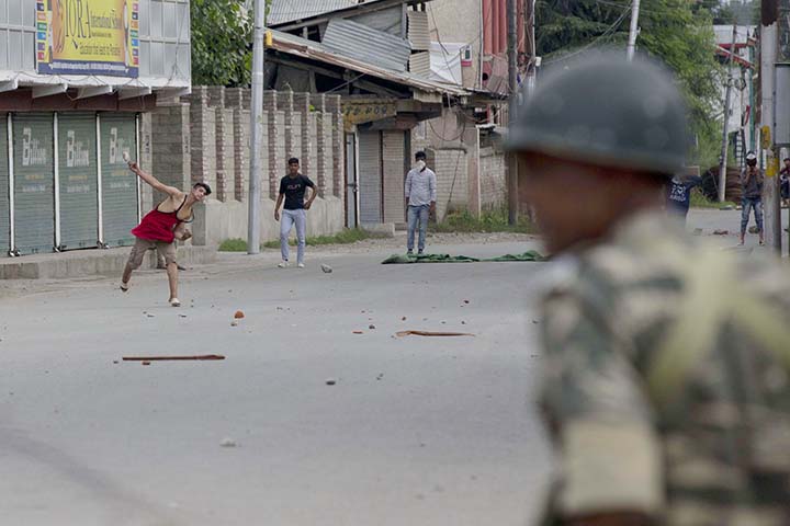Kashmiri Muslim protesters throw stones at Indian paramilitary soldiers during curfew like restrictions in Srinagar, India on Friday.