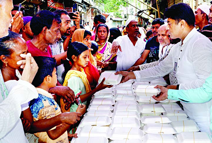 Councillor of 26 No. Ward of DSCC Hasibur Rahman Manik distributing food among the destitute organised on the occasion of National Mourning Day in the city's Rasulbag area on Tuesday.