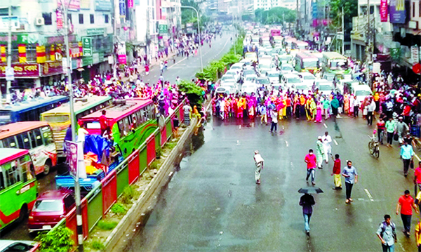 Workers of Alif Apparels block the main road of Shyamoli area in Dhaka protesting sudden closure of their factory and demanding arrears on Wednesday.