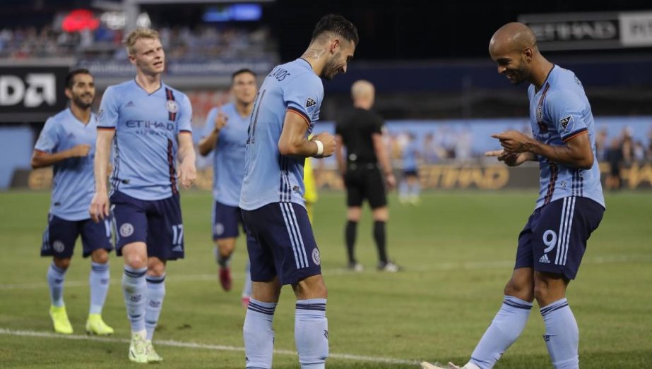 Teammates watch as New York City FC midfielder Valentin Castellanos (center) and New York City FC forward Heber (right) do a little dance after Castellanos scored during the first half of an MLS soccer match against Columbus Crew in New York on Wednesday.