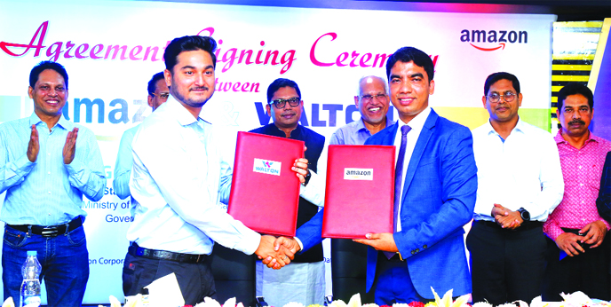 Shashank Pandey, Country Manager of Amazon BD and Engineer Liakat Ali, Executive Director of Walton Group, exchanging an agreement signing document at Waltonâ€™s corporate office in the city on Thursday. State Minister for Information and Communicati