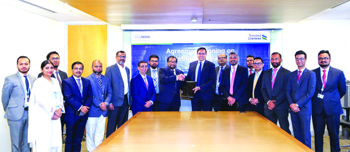 Deepal Abey Wickrema, Managing Director of NestlÃ© Bangladesh Limited and Naser Ezaz Bijoy, CEO of Standard Chartered Bangladesh, exchanging an agreement signing document at the bank's head office in the city recently. Senior officials from both the or