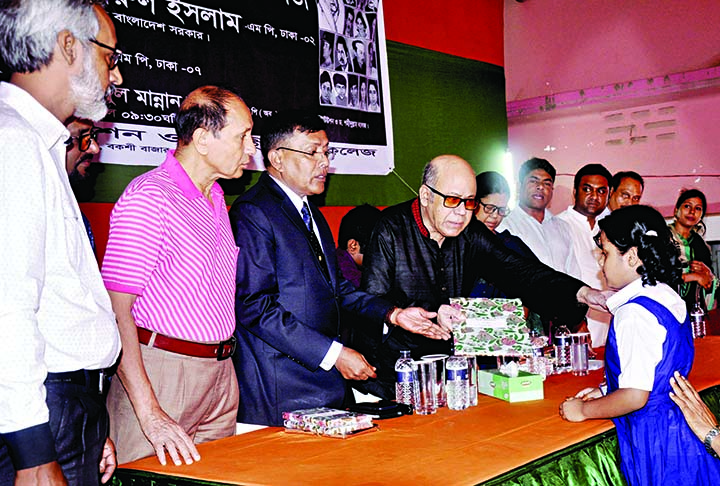 Chairman of the Governing Body of the city's Nabakumar Institute and Dr Shahidullah College Advocate Quamrul Islam, MP giving away prize to a winner of a drawing competition organised by the institution on the occasion of National Mourning Day on its p