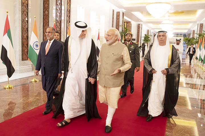 Indian Prime Minister Narendra Modi, (centre right), walks with Khaldoon Khalifa al-Mubarak, Chairman of the Abu Dhabi Executive Affairs Authority, (centre left), after arriving in Abu Dhabi, United Arab Emirates on Friday.