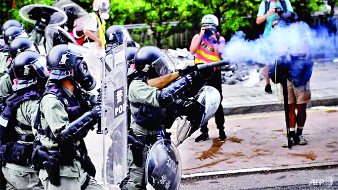 Riot police fire tear gas against protesters at Kowloon Bay in Hong Kong on Saturday.