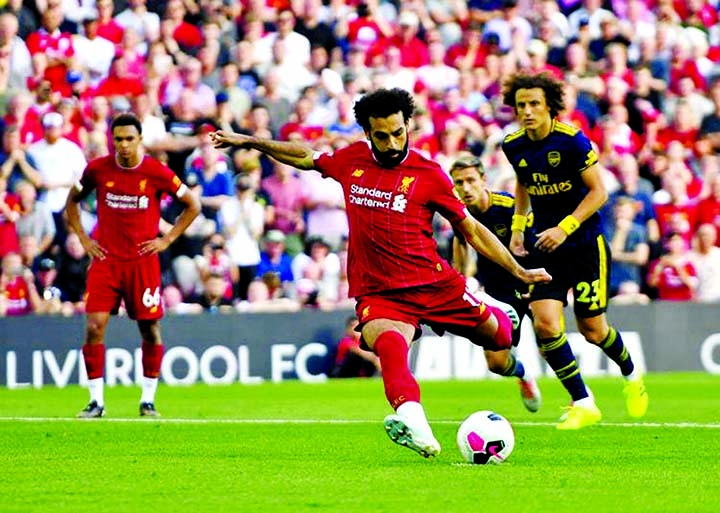 Liverpool's Mohamed Salah scores his side's second goal of the game from the penalty spot during the English Premier League soccer match against Arsenal at Anfield, Liverpool, England on Saturday.