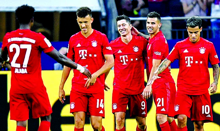 Bayern's Robert Lewandowski (second from right) celebrates after scoring his third goal during the German Bundesliga soccer match between FC Schalke 04 and Bayern Munich in Gelsenkirchen, Germany on Saturday.