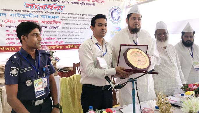 Md Saidul Arefin, UNO, receiving a crest from Hazrat Shah Sufi Syed Saifuddin Al- Hasani , Chairman Hazrat Mohmmad Moinuddin Maizbhandari Trust at a reception of meritorious students of SSC and HSC of Fatikchhari Upazila on Sunday.