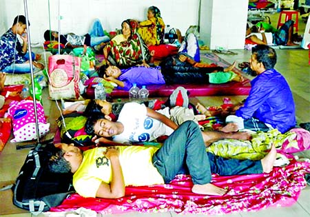 Dengue patients lying on the floor inside the Mugda General Hospital in city on Tuesday as the hospital run out of beds amid increasing number of dengue patients.