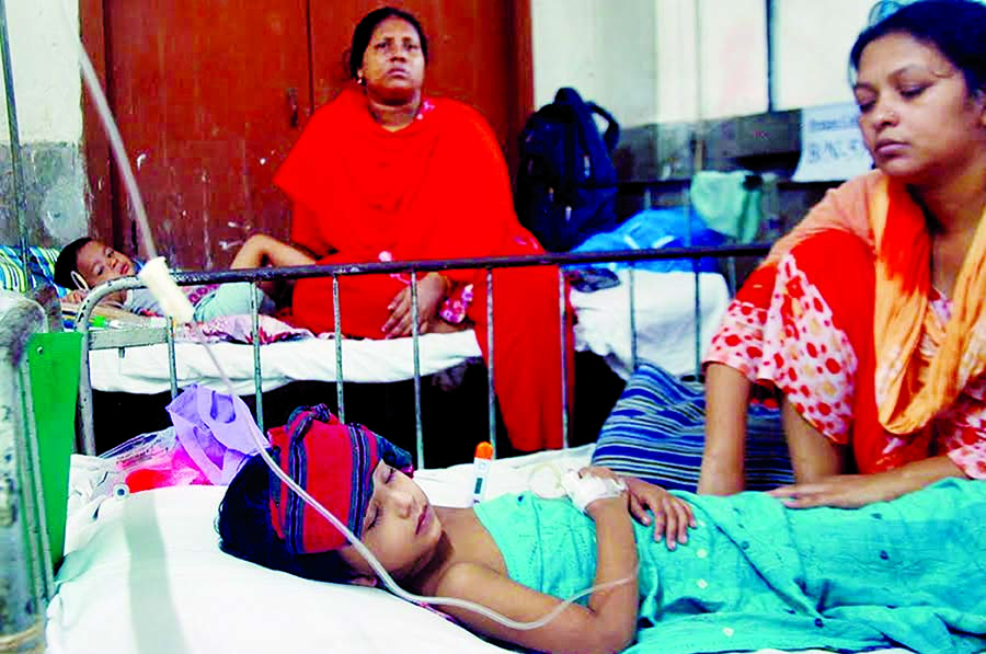 An anxious mother attends her baby infected with dengue at Dhaka Shishu Hospital on Wednesday.