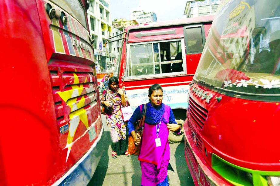 Pedestrians scramble to cross in the middle of the road when a bus slowed down, risking their lives. This photo was taken from Purana Paltan intersection in Dhaka on Friday.