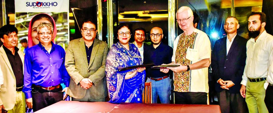Dr. Rubana Huq, President of Bangladesh Garment Manufacturers and Exporters Association (BGMEA) and Erling Petersen, Team Leader of Sudokkho (a UK and Swiss government funded programme), exchanging a collaboration agreement signing document at BGMEA head