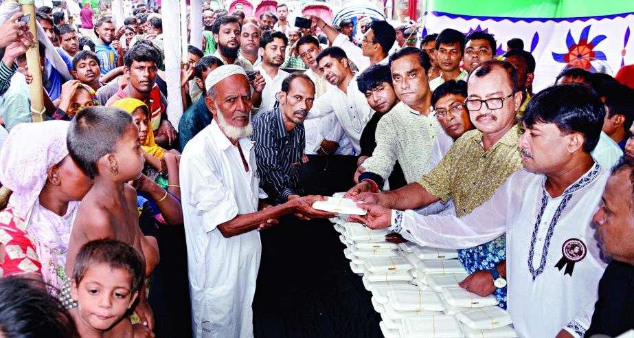 President of Bangladesh Swechchhasebak League and General Secretary of Swechchhasebak League , Dhaka South Advocate Molla Kawser and Arifur Rahman Titu respectively giving away food among the poor at Bangabandhu Avenue in the city on Saturday at a funct