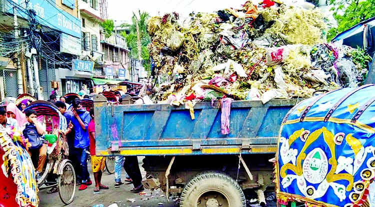 A Dhaka South City Corporation (DSCC) hauler load garbage plying on the main road at Siddiq Bazar in Old Dhaka in the middle of the day on Saturday, despite inconveniences to both motorists and pedestrians.