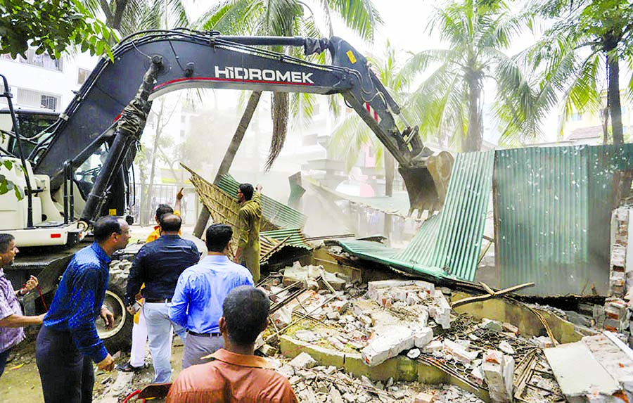 As part of continuous eviction drive, DNCC authorities dismantling illegal structures at Tajmahal Road in city's Mohammadpur area on Sunday.