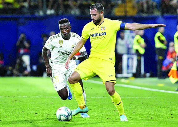 Villareal's Mario Gaspar vies for the ball with Real Madrid's Vinicius Junior during the Spanish La Liga soccer match between Villarreal and Real Madrid in the Ceramica stadium in Villarreal, Spain on Sunday.