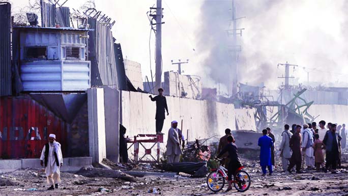 Angry Afghan protesters burn tyres and shout slogans at the site of a blast in Kabul on Tuesday.
