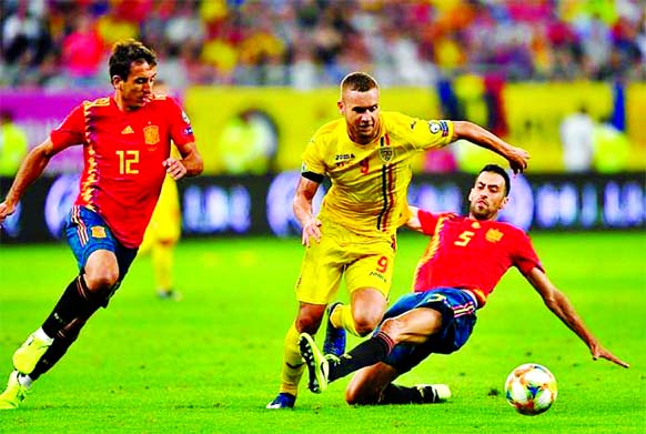Spain's Mikel Oyarzabal (L) and Spain's midfielder Sergio Busquets (R) vie for the ball with Romania's forward George Alexandru Puscas (C) during the Euro 2020 football qualification match between Romania and Spain in Bucharest, Romania on Thursday.