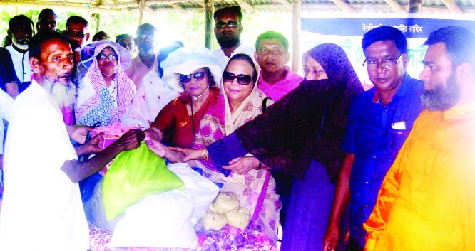 GABTOLI(Bogura): Relief goods were distributed among the flood- hit and landless people at Aatbaria Village in Gabtoli Upazila organised by Ladies Society, Dhaka on Friday.