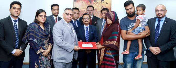 Tarique Afzal, President and Managing Director of AB Bank Ltd, handing over a cheque to Parvin Akter, widow of a security guard Jahangir Alam, who was killed during an attempted robbery while on duty at the Bank's Board Bazar ATM Booth on Saturday. Bank