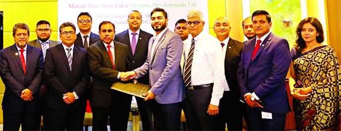 Abrarul Haque, Chief Executive Officer of Manama Developments Ltd (MDL) and Syed Rafiqul Haq, Deputy Managing Director of Mutual Trust Bank Ltd (MTB), exchanging an agreement signing document at MTB centre in the city recently. SM Baki Billah, DGM (Operat