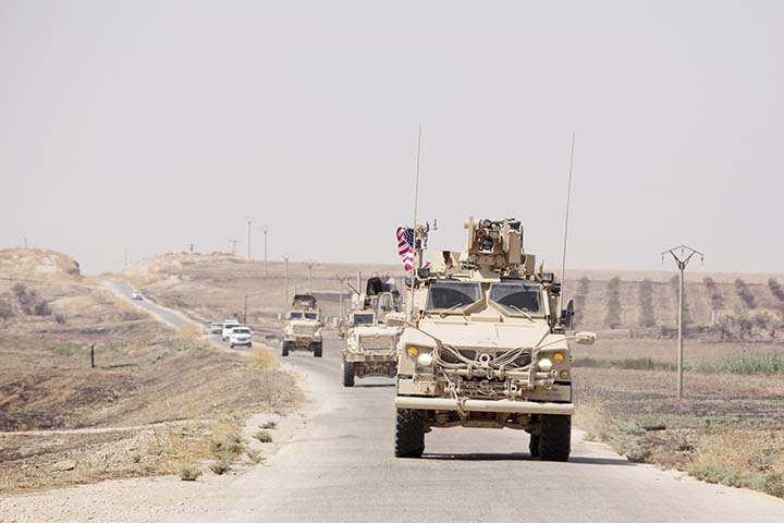 U.S. armored vehicles travel in a joint patrol of the safe zone between Syria and the Turkish border with the Tal Abyad Military Council near Tal Abyad, Syria on Friday.