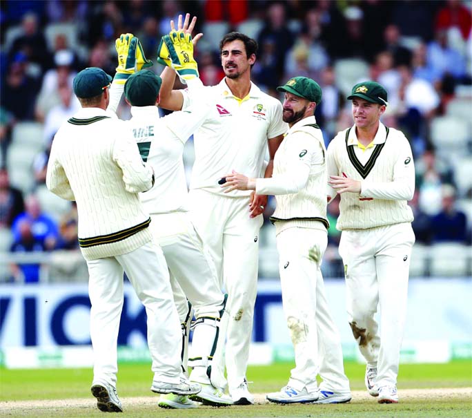 Australia's Mitchell Starc (center) celebrates with teammates after dismissing England's Jonny Bairstow during day five of the fourth Ashes Test cricket match between England and Australia at Old Trafford in Manchester, England on Sunday.