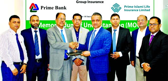 Kazi Abul Manjur, SEVP of Prime Islami Life Insurance Limited (PILIL) and ANM Mahfuz, Head of Consumer Banking of Prime Bank Limited, exchanging a MoU signing document to protect the insurable interest of bank's Hasanah Platinum Credit Card holders at th