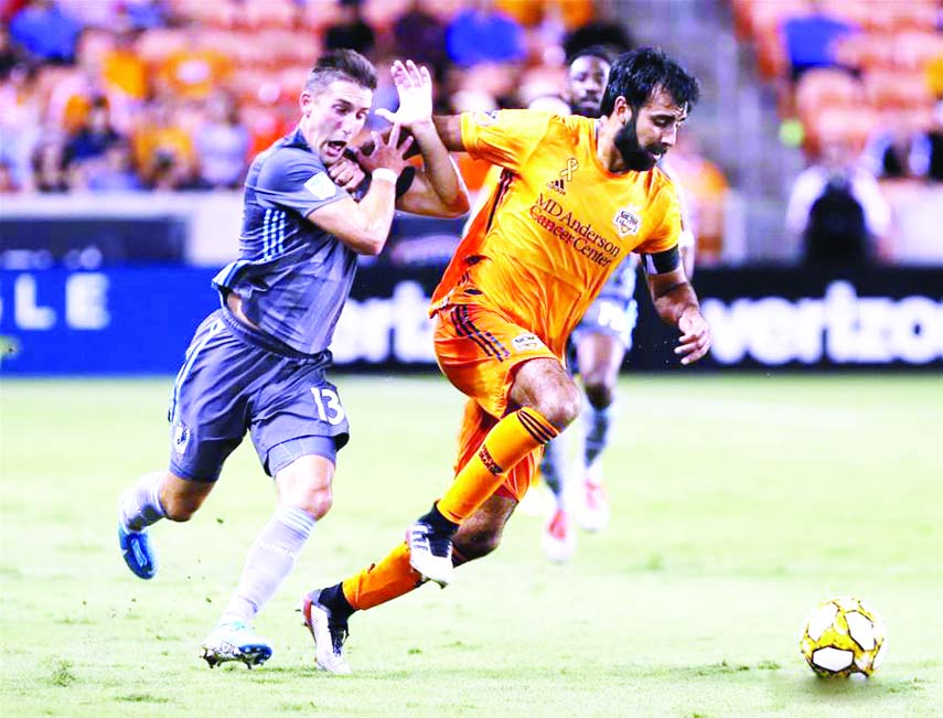 Kevin Garcia (right) of Houston Dynamo vies with Ethan Finlay of Minnesota United during a regular season soccer match between Houston Dynamo and Minnesota United at the Major League Soccer in Houston, the United States on Wednesday.