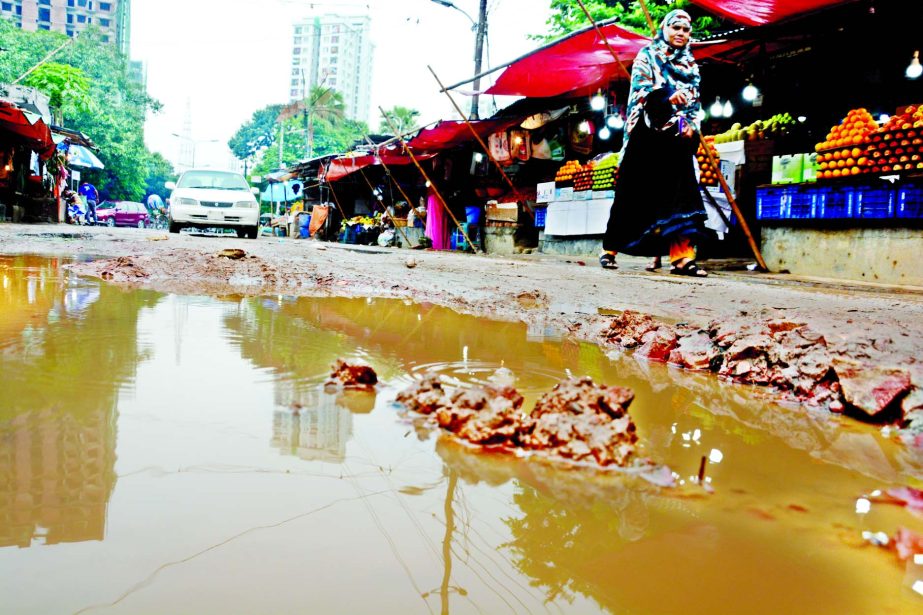 A big pothole developed on the road near AGB Colony in city's Motijheel area after rain water being stagnant for the last two days creating lots of hurdles, causing sufferings to commuters and pedestrians. This photo was taken on Friday.