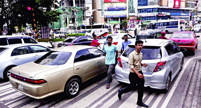 Motorists keep driving on the Zebra crossing blocking the path for pedestrians movement while jaywalkers remain reluctant to use it. This photo was taken from the street at Gulshan-2 in Dhaka on Saturday.
