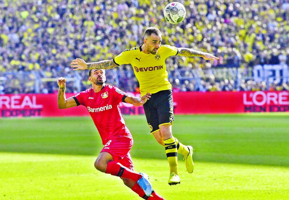 Leverkusen's Karim Bellarabi (left) and Dortmund's Paco Alcacer challenge for the ball during the German Bundesliga soccer match between Borussia Dortmund and Bayer Leverkusen in Dortmund, Germany on Saturday.