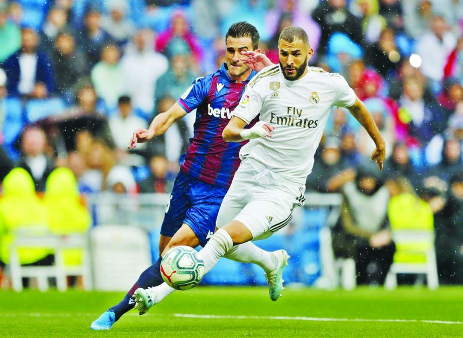 Real Madrid's Karim Benzema (right) vies for the ball with Levante's Nemanja Radoja during the Spanish La Liga soccer match between Real Madrid and Levante at the Santiago Bernabeu stadium in Madrid, Spain on Saturday.