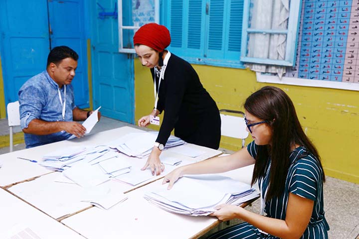 Tunisian volunteers count ballots at a polling station in Sousse, south of the capital Tunis